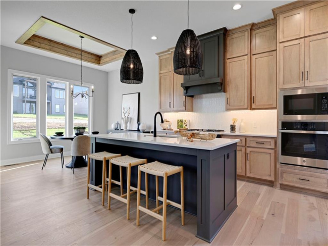 Natural wood cabinetry and a central island ground this light-filled culinary space.