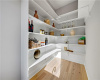 Ample built-in shelving and light hardwood flooring define this functional walk-in pantry.