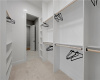 Custom built-in shelving and ample hanging rods maximize organization in this plush carpeted closet.