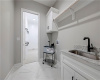 Polished tile flooring and a built-in utility sink elevate this functional laundry space.