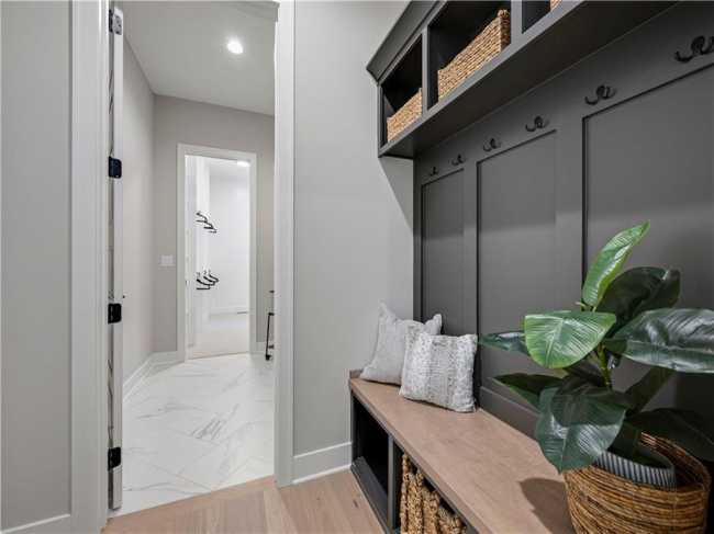 Custom built-in bench seating with cubbies and paneling organizes this practical mudroom entry.