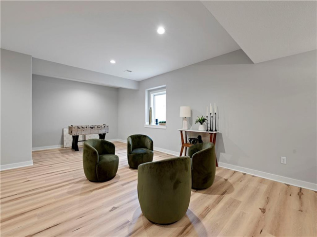Warm wood flooring and recessed lighting define this versatile lower level recreation space.