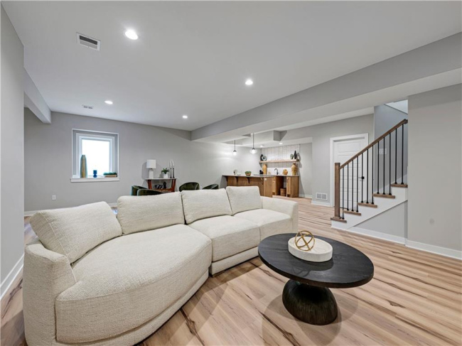 Smooth wood floors and recessed lighting anchor this open walk-out lower level layout.