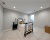 Recessed lighting and soft carpeting create a cozy atmosphere in this quiet basement bedroom.