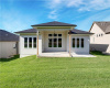 A spacious covered patio overlooks a lush green lawn under clear blue skies.