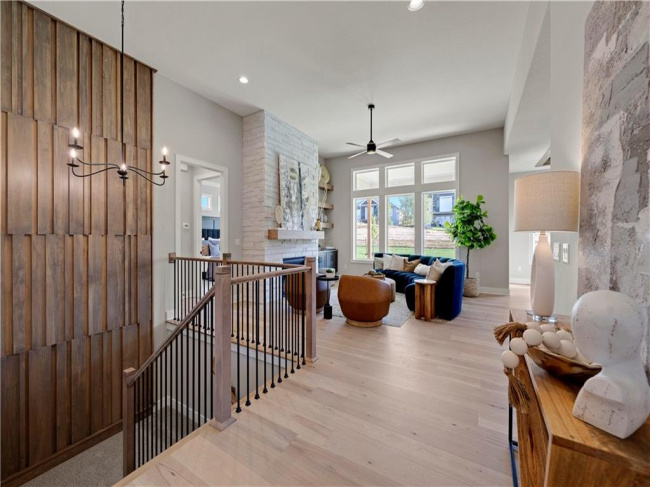 Gleaming hardwood floors and a striking wood-paneled wall transition seamlessly into the open living area.